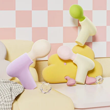 pastel color mini percussion massager collection styled in cozy room setting with decorative display