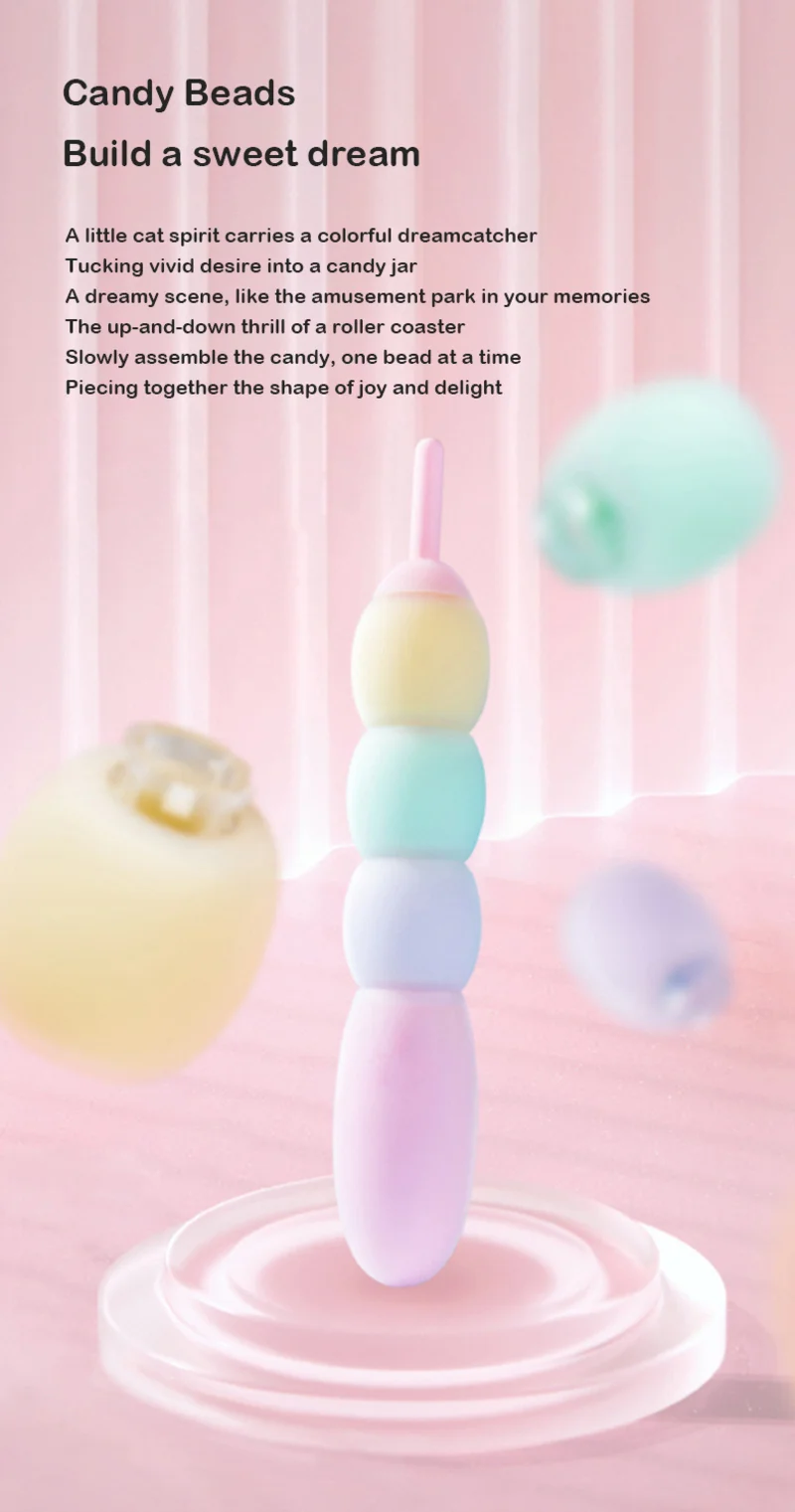 Pastel modular candy bead vibrator standing upright in a dreamy pink display scene with soft silicone bead segments