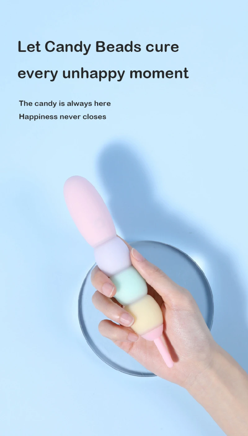 Handheld pastel bead vibrator in a soft blue setting highlighting discreet design and playful adult product styling