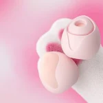 Peach-shaped clitoral vibrator in soft pink shown from two angles