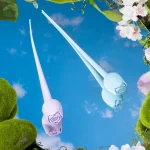 Lavender and blue rose bud vibrators reflected on mirror surface with floral spring themed backdrop