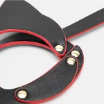 Detailed close-up of riveted cat mask edge with layered faux leather and contrast red piping