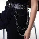 Black double grommet belt with hanging chain details and ring accent