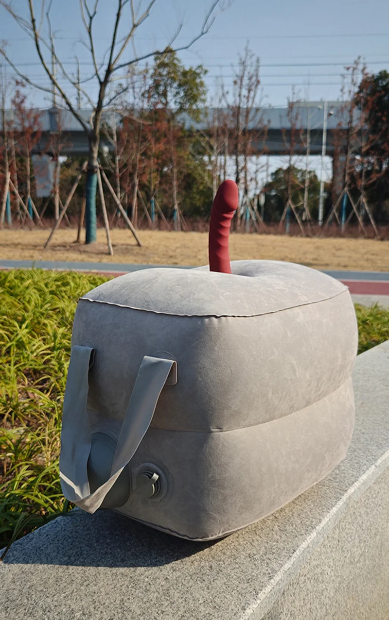 Portable inflatable stool with carry handle and novelty phallic top outdoors