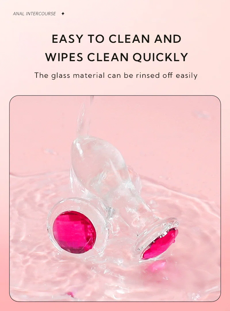 Clear glass anal plug with pink jeweled base being rinsed with water Discreet Sex Toys Brand - HooHss