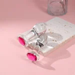 Clear glass anal plugs with pink gem bases on a pink surface Discreet Sex Toys Brand - HooHss