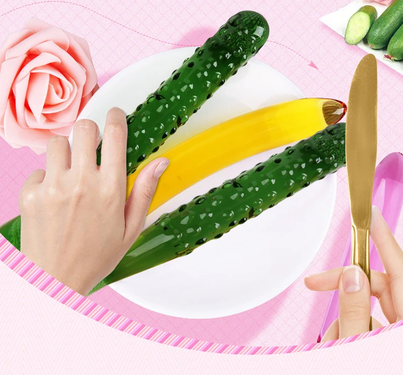 Cucumber shaped glass dildo beside banana on plate with hands holding cutlery Discreet Sex Toys Brand - HooHss