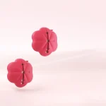 Pair of pink flower-shaped nipple clips suspended against a soft background Discreet Sex Toys Brand - HooHss
