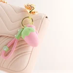Strawberry shaped keychain charm hanging from a handbag zipper Discreet Sex Toys Brand - HooHss