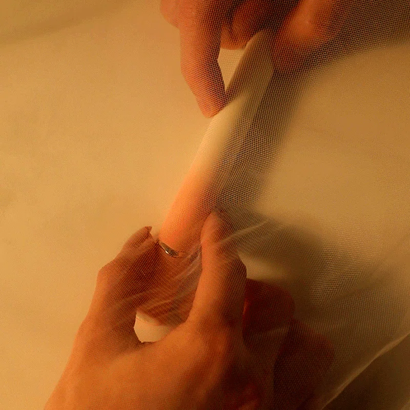 Slim vibrator held in hands behind sheer fabric Discreet Sex Toys Brand - HooHss